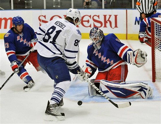 Branká NY Rangers Henrik Lundqvist zasahuje proti Philu Kesselovi z Toronta (v bílém), pihlíí bek Michal Rozsíval.