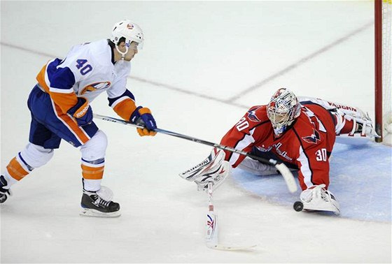 Branká Washingtonu Michal Neuvirth zasahuje proti Michaelu Grabnerovi z New Yorku Islanders.