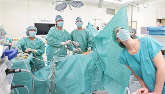 Lékai a sestry pozorují na monitorech obraz biní dutiny pacienta, který penáí speciální kamera.