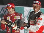 Lewis Hamilton (vpravo) a Fernando Alonso slav na stupnch vtz korejsk Velk ceny. 