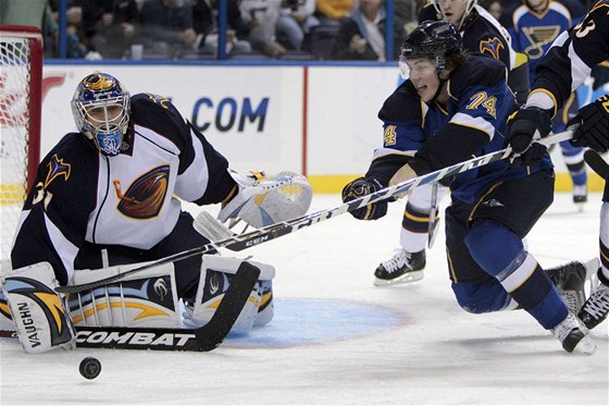 T.J. Oshie ze St. Louis v anci ped gólmanem Ondejem Pavelcem z Atlanty.