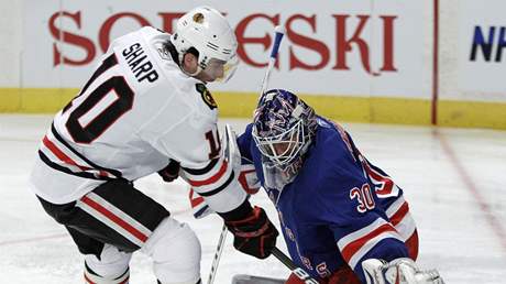 Brankø New Yorku Rangers Henrik Lundqvist èel njezdu Patricka Sharpa z Chicaga. 