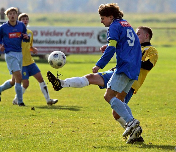 Kapitán Drmoulu Vlastimil Kotous (v modrém) v derby s Mariánskými Láznmi.