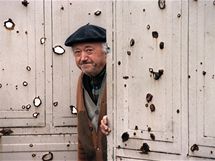 Star obyvatel Vukovaru vykukuje z prostlench vrat svho domu (1991)