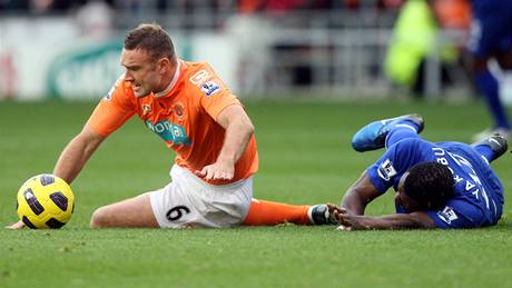 Fotbalista Ian Evatt z Blackpoolu sleduje mí, za ním leí Yakubu z Evertonu