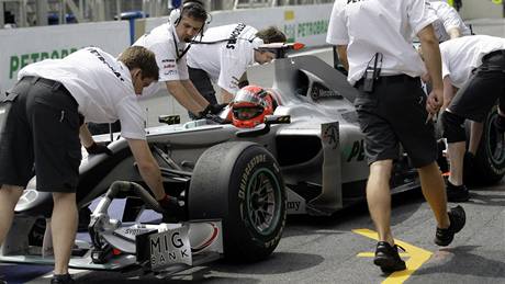 Vz Mercedes s Michaelem Schumacherem v kokpitu zatlaují mechanici do garáe.