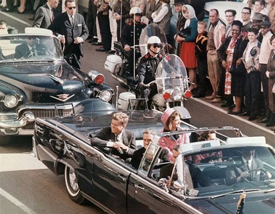 JFK s Jacqueline projídjí ulicemi Dallasu. Do smrtících výstel zbývají okamiky.