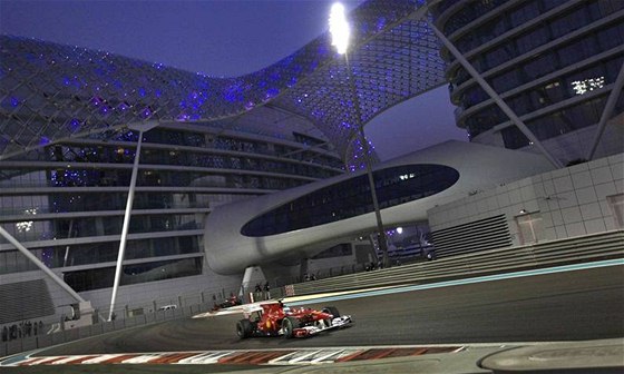 PED HOTELEM. Fernando Alonso z Ferrari projídí kolem moderního hotelu Yas Marina bhem kvalifikace Velké ceny Emirát.