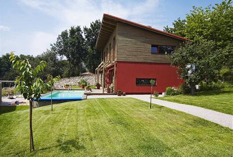 Jednoduchou hmotu domu s pultovou střechou v exteriéru obohacuje předsazená dřevěná pergola (v budoucnu vznikne v patře balkon) a obložení Jednoduchou hmotu domu s pultovou střechou v exteriéru obohacuje předsazená dřevěná pergola (v budoucnu vznikne v patře balkon) a obložení