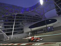 PED HOTELEM. Fernando Alonso z Ferrari projd kolem modernho hotelu Yas Marina bhem kvalifikace Velk ceny Emirt.