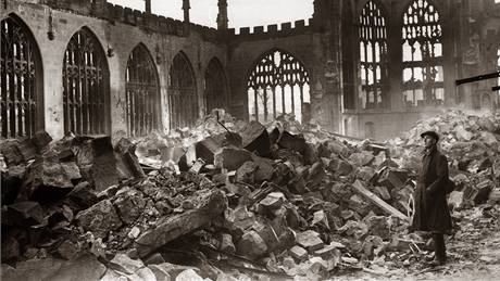 Mu stojí uprosted sutin rozbombardované katedrály v Coventry. (listopad 1940)