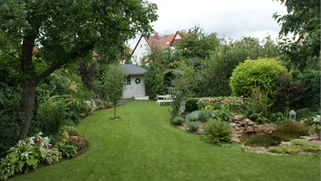 Zahrada je vytvoena na parcele trojúhelníkového pdorysu, ohraniená po obou stranách pestrými zelenými mantinely; ve pici vzadu je ukonená pvabným bílým zahradním domkem