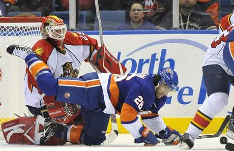 Glman Tom Vokoun z Floridy pacifikuje nejen puk, ale tak  Matta Moulsona z New York Islanders.