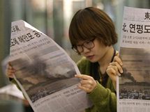 Korejky si tou noviny se zprvou o ostelovn ostrova Jonpchjong KLDR (23. listopadu) 