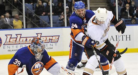 Obrnce New Yorku Islanders Radek Martnek (uprostøed) se sna vyèistit prostor pøed svm brankøem Rickem DiPietrem, do ance se tlaè Joffrey Lupul z Anaheimu. 