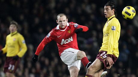 Wayne Rooney z Manchesteru Unites stílí ped dobíhajícím Marvánem ammachem z Arsenalu.
