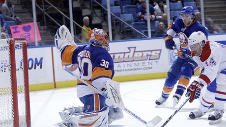 Tomá Plekanec z Montrealu najídí na Dwaynea Rolosona z NY Islanders.