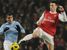 Laurent Koscielny z Arsenalu (vpravo) zastavuje Carlose Tevze z Manchesteru United.