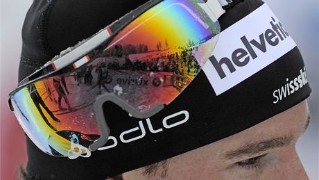 V CÍLI Fotograf AP vyuil odrazu v brýlích Daria Cologny, aby zachytil ostatní závodníky v cíli závodu Tour de Ski.