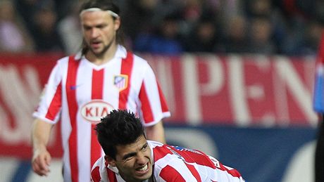 Tomá Ujfaloi (v pozadí) a  Sergio Leonel 'Kun' Aguero z Atlétika Madrid v zápase se Santanderem. 