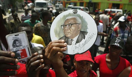 Pznivci vtali bvalho haitskho dikttora Jean-Claude Duvaliera po pistn v Port-au-Prince s portrty jeho otce (17. ledna 2010)