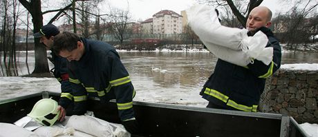 Hasii pokládali pytle s pískem ke dveím budovy lodnice u Chebského mostu.