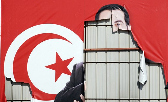 Plakát s potrhanou podobiznou bývalého prezidenta Tuniska Zína Abidína bin Alího v Tunisu (17. ledna 2011)