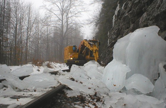 Bagr odstrauje ledopád ohroující elezniní tra mezi Josefovým Dolem a Smrovkou.