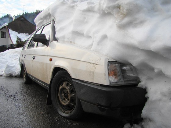 Padající sníh ze stechy zasypal dv auta.