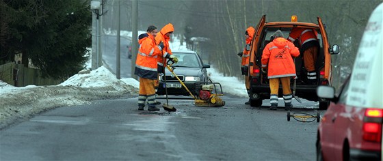 Silniái opravují výtluky studenou balenou smsí. 