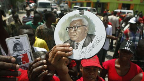 Píznivci vítali bývalého haitského diktátora Jean-Claude Duvaliera po pistání v Port-au-Prince s portréty jeho otce (17. ledna 2011)