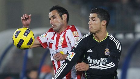 UBRÁNÍM T. Juan Manuel Ortiz z Almerie odstavuje od míe Cristiana Ronalda z Realu Madrid.