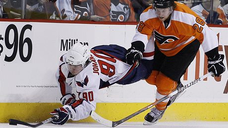 Washingtonský kapitán Marcus Johansson neuspl s pokusem o prnik kolem mantinelu ped hráe Philadelphie Clauda Girouxe v úterním zápase NHL.