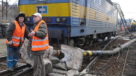 Jet v nedli eili dlníci na seaovacím nádraí v Malomicích na trati Brno - eská Tebová následky vykolejení dvou cisteren a nárazu osobního vlaku do sloupu dráního vedení. (23. ledem 2011)