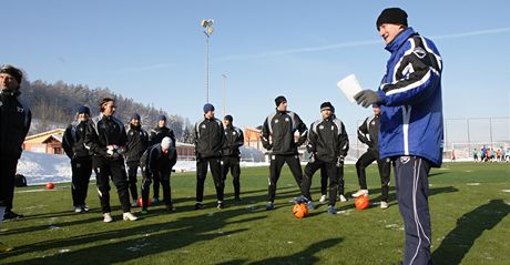Zlíntí fotbalisté poslouchají na zimním soustední pokyny trenéra Kalivody (vpravo)