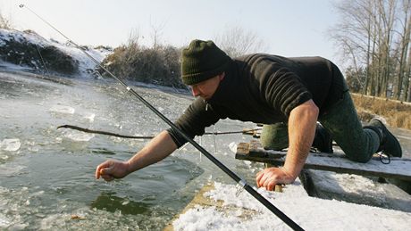 Jií Hejl z Jarome chytá ryby pod ledem na rybníku v Holohlavech.