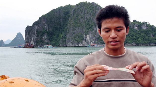 Prvodce John ukazuje bankovku s jedním z ostrov v zátoce Ha Long