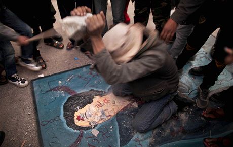 Libyjec nií portrét Muammara Kaddáfího bhem demonstrace v Tobruku (26. února 2011)