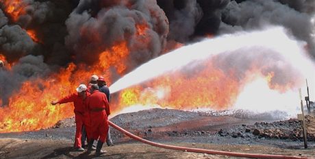 Irátí hasii bojují s poárem ropovodu poblí rafinerie Bajdí. Archivní snímek ze záí 2003