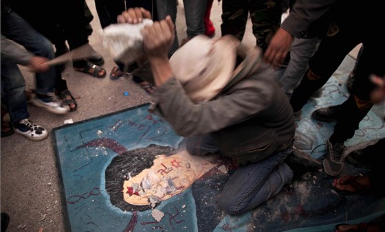 Libyjec nií portrét Muammara Kaddáfího bhem demonstrace v Tobruku (26. února 2011)