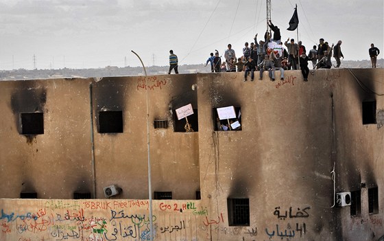 Libyjtí demonstranti stojí na stee vypálené policejní stanice v Tobruku. (23. února 2011)