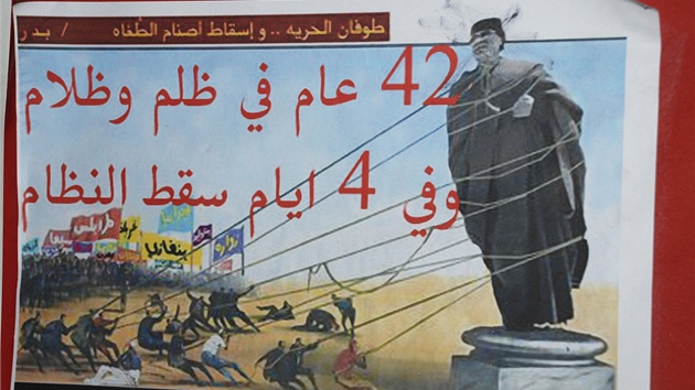 "Píval svobody povalí modly útlaku. Po 42 let represe a temnoty reim padne bhem ty dn. Vyvrácení lidské modly je náboenskou a národní povinností." Propagandistický plakát proti Kaddáfímu v ulicích Benghází. (22. února 2011)