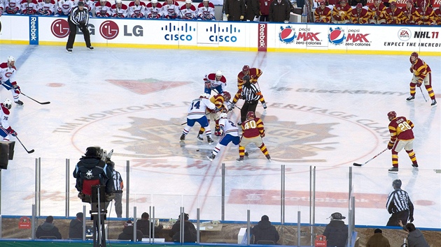 Úvodní bully duelu pod oteveným nebem mezi Calgary a Montrealem.