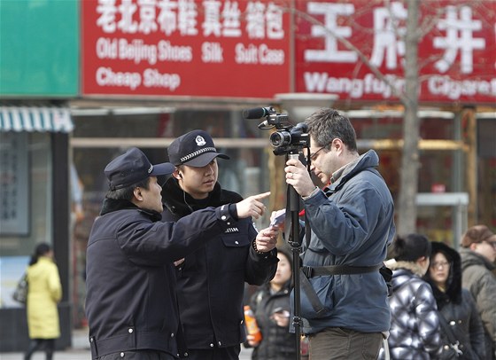 Policisté vykazují kameramana AP z obchodní tídy v centru Pekingu