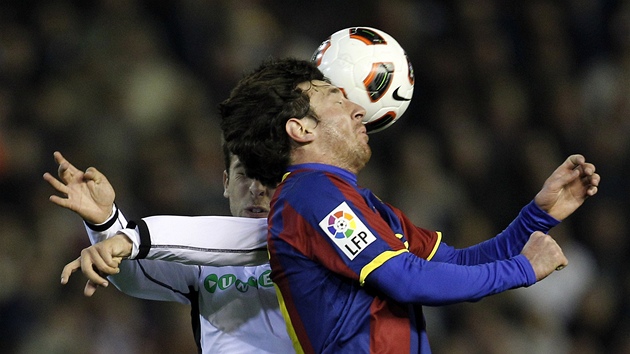 Lionel Messi z Barcelony v hlavikovém souboji s Jordim Albou z Valencie. 