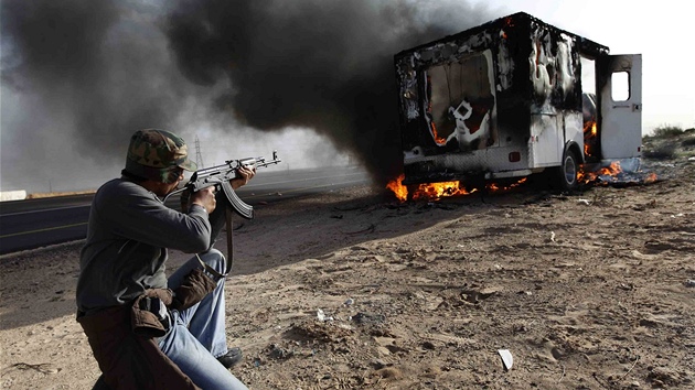 Libyjský povstalec míí na auto Kaddáfího jednotek poblí msta Brega (2. bezna 2011)