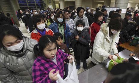 Evakuovaní Japonci si rozdlují jídlo v provizorním písteku ve Fukuim