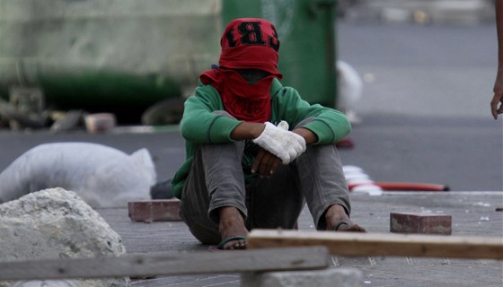 Mladý íitský demonstrant odpoívá po bitv s policií v centru Manámy  (16. bezna 2011)