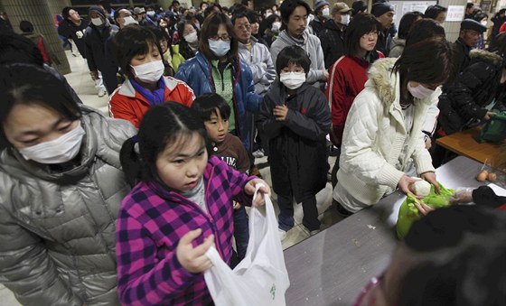 Evakuovaní Japonci si rozdlují jídlo v provizorním písteku ve Fukuim