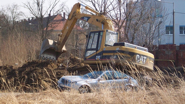 Nepozorný bagrista na stavb v Plzni zniil luxusní mercedes